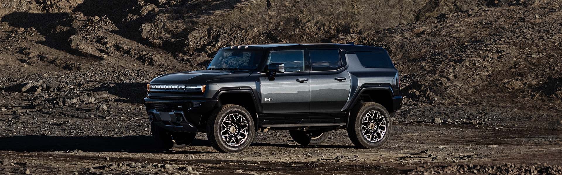 Black 2025 Hummer EV SUV parked on a gravel road