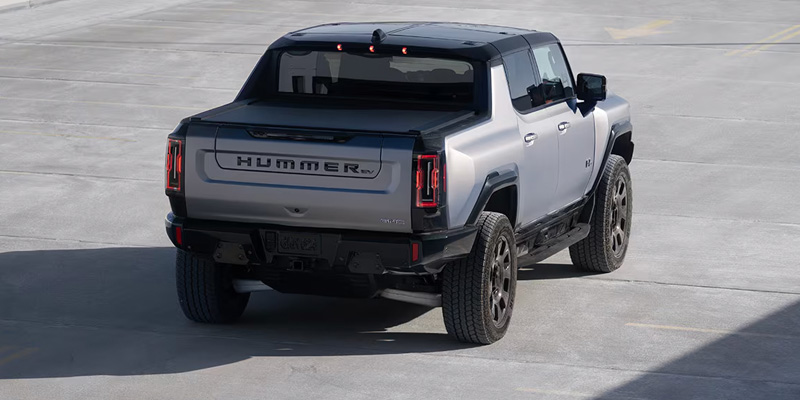 A 2026 GMC HUMMER EV Pickup parked in a lot, showcasing its modern design and robust features.